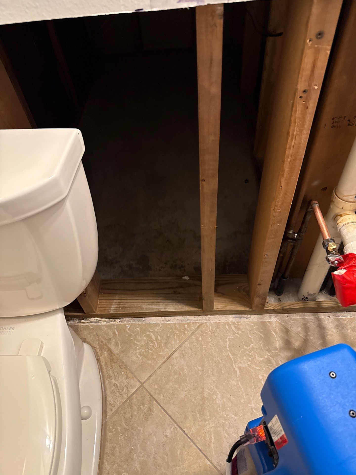 Technician using a Protimeter moisture meter to verify the drying progress of structural wood framing during the restoration process.