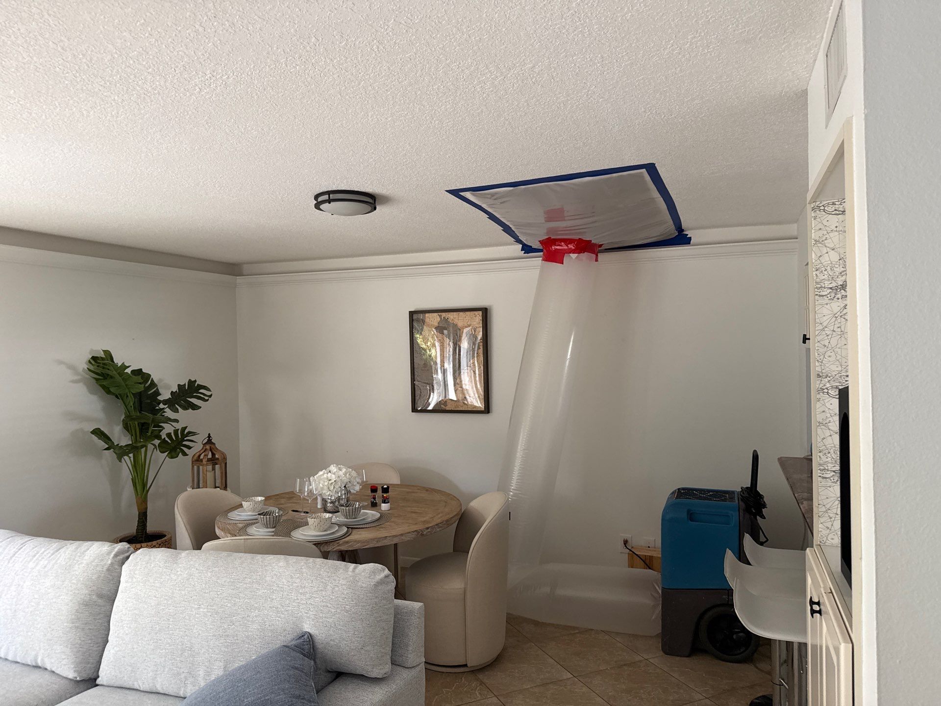 Ceiling containment barrier and air-moving equipment used during a high-level water damage restoration project.
