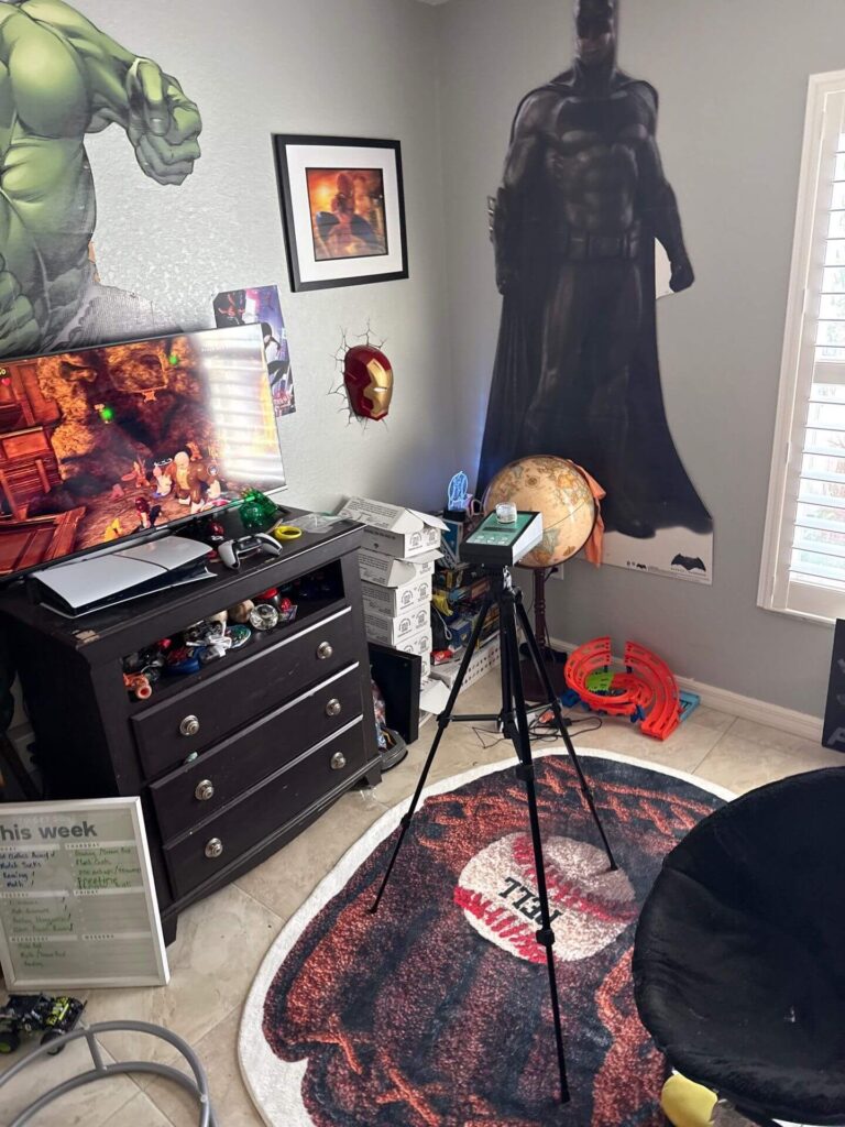 High-volume air sampling pump on a tripod in a bedroom for mold spore and allergen laboratory analysis.