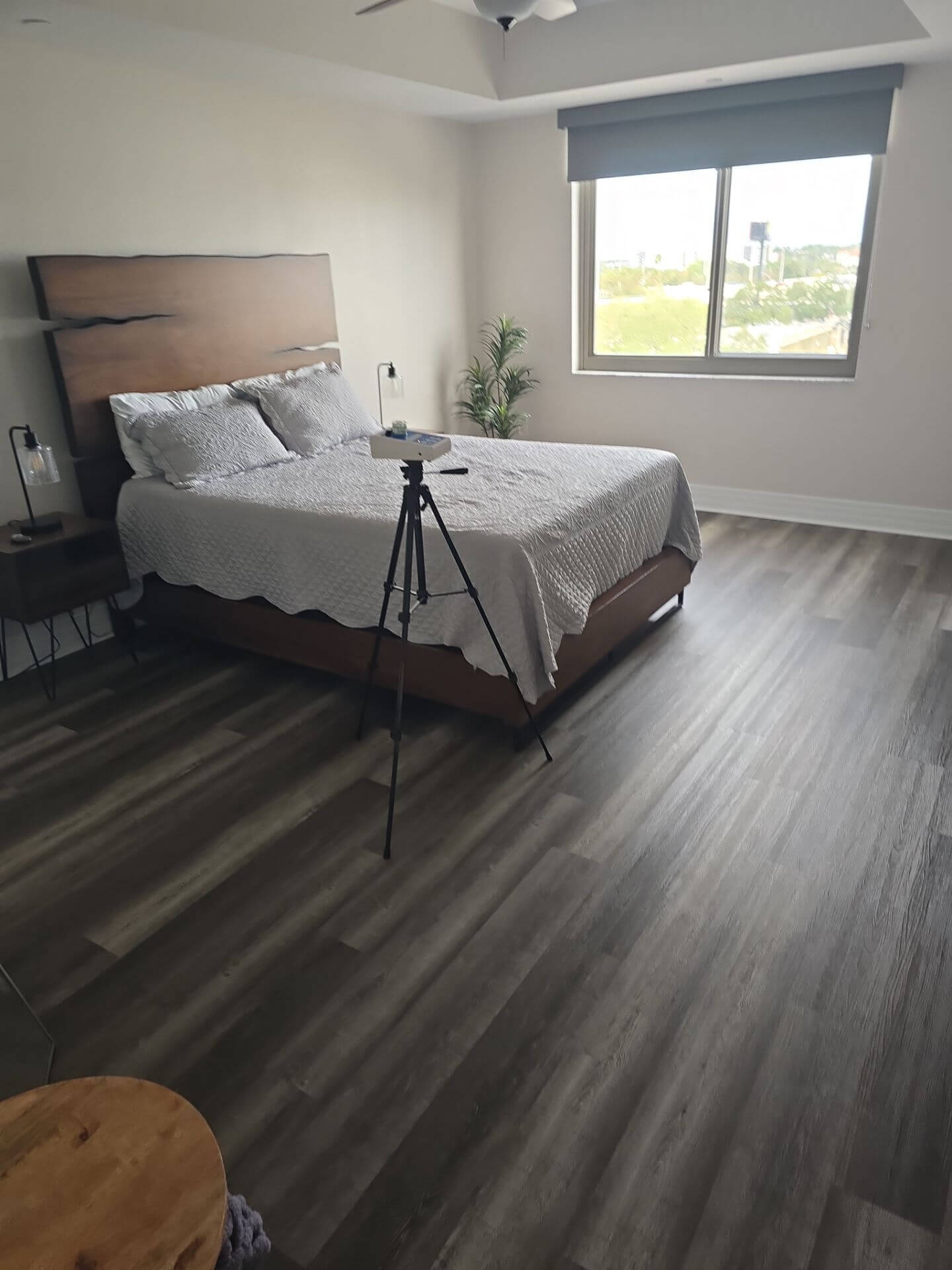 Professional indoor air quality monitoring equipment set up in a modern residential bedroom for allergen and pollutant testing.