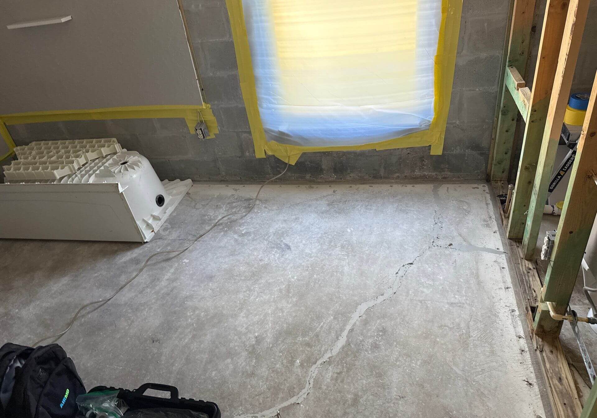 Professional mold remediation containment zone showing plastic barriers and sealed windows to prevent cross-contamination during cleanup.