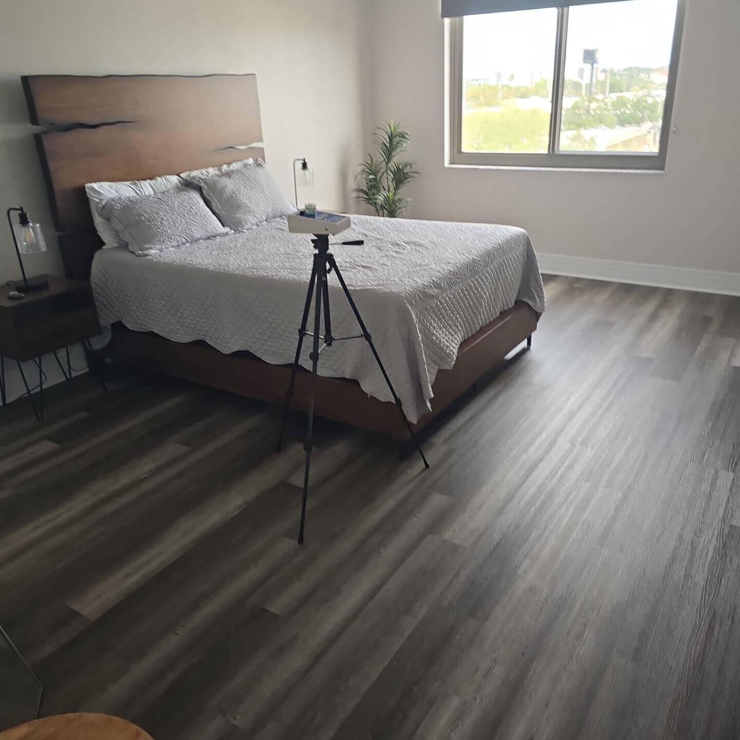 Professional indoor air quality monitoring equipment set up in a modern residential bedroom for allergen and pollutant testing.
