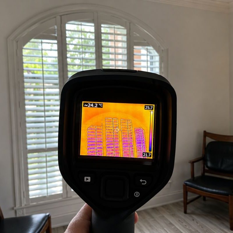 Thermal imaging camera inspecting a residential window for temperature differences, air leaks, moisture concerns, and possible hidden mold issues during an indoor environmental assessment.